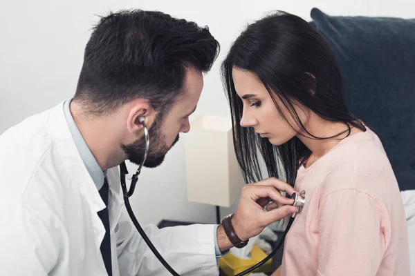 Primer plano del médico escuchando la respiración de la paciente femenina - foto de stock