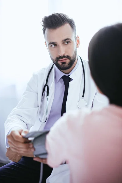 Jovem médico bonito ouvir paciente feminino — Fotografia de Stock