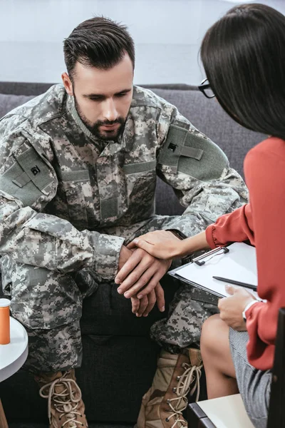 Female psychiatrist supporting depressed soldier with post traumatic syndrome during therapy session — Stock Photo