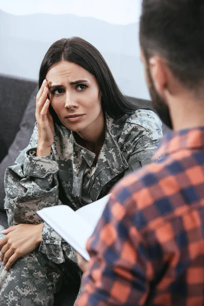 Soldado mujer deprimida con ptsd sentado en sesión de terapia con psiquiatra - foto de stock