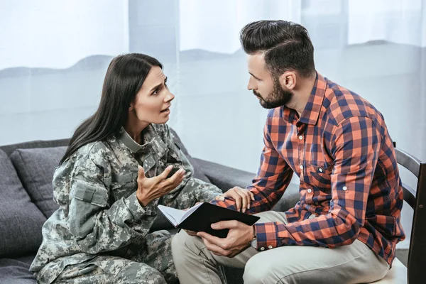Женщина-солдат с посттравматическим синдромом просит помощи у психиатра во время терапии — стоковое фото