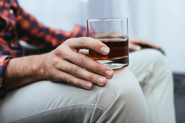 Plan recadré de jeune homme tenant un verre de whisky — Photo de stock