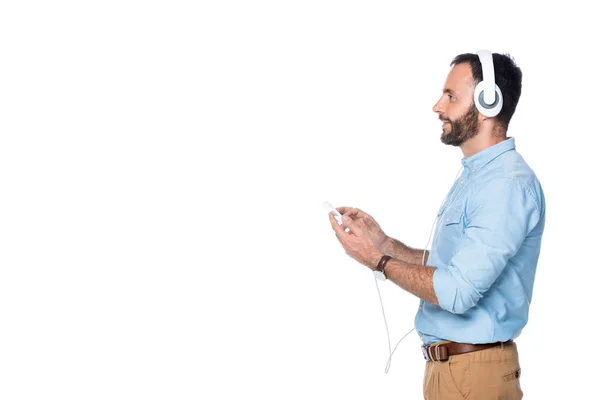 Вид збоку усміхненого чоловіка, що слухає музику ізольовано на білому — стокове фото