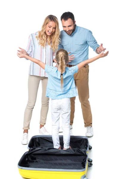Здивовані батьки з дочкою, що стоїть в дорожній сумці ізольовані на білому — стокове фото