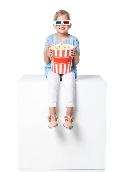 Kid with 3d glasses sitting on white cube isolated on white — Stock Photo