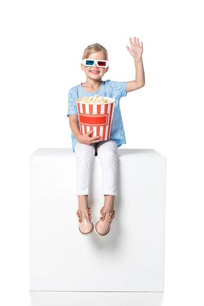 Enfant avec popcorn assis sur cube blanc isolé sur blanc — Photo de stock