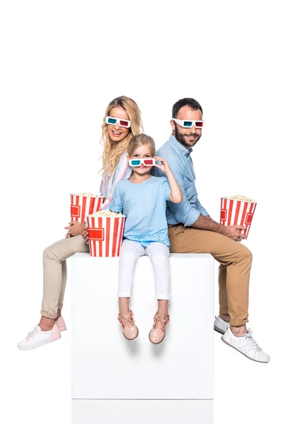 Familia con palomitas de maíz sentado en cubo blanco aislado en blanco - foto de stock