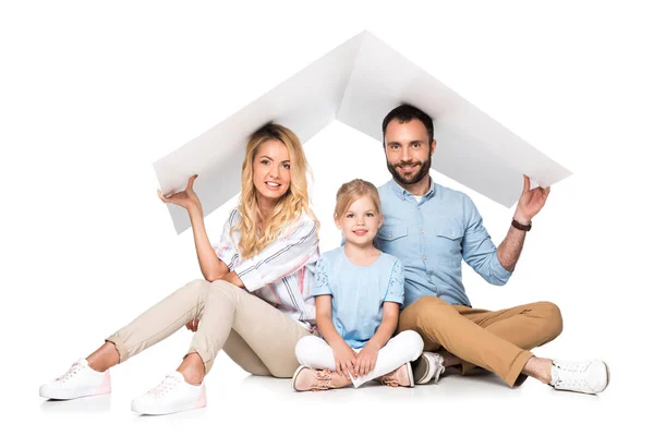 Parents with daughter holding white roof over heads isolated on white, family insurance concept — Stock Photo