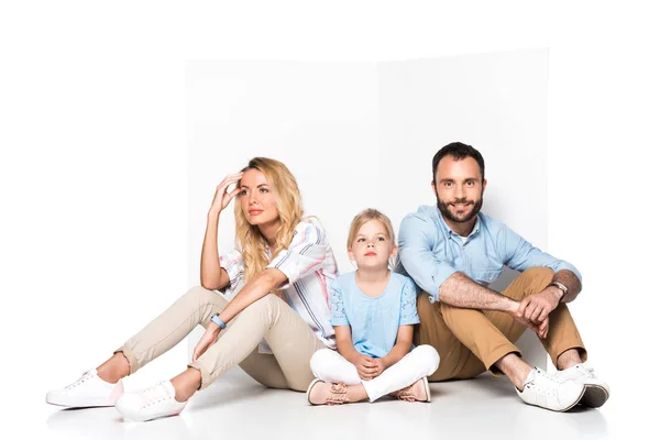 Семья, сидящая на полу изолированная на белом — стоковое фото