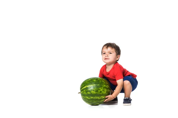 Criança tentando levantar melancia isolada em branco — Fotografia de Stock