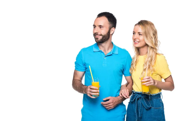 Couple holding glasses with orange juice and looking away isolated on white — Stock Photo