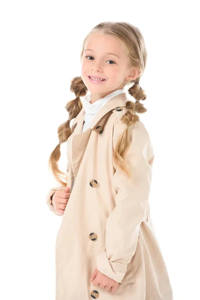 Усміхнена дитина позує в бежевому пальто, ізольована на білому — стокове фото