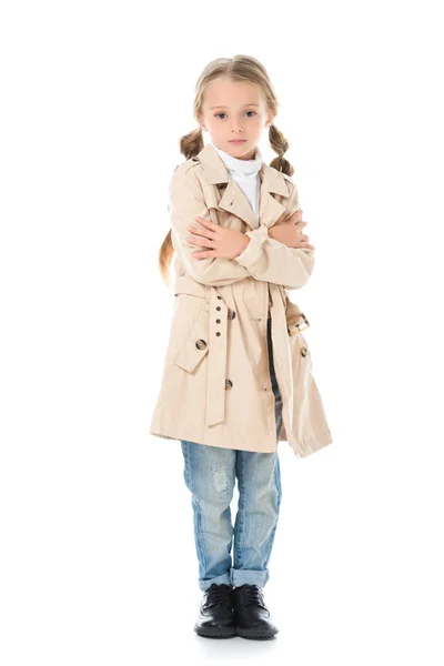 Чарівна дитина позує в бежевому пальто, ізольована на білому — стокове фото