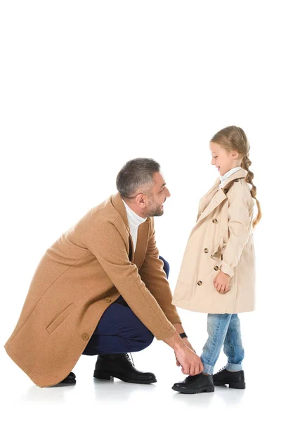 Padre e figlia in cappotti beige che si guardano, isolati su bianco — Foto stock