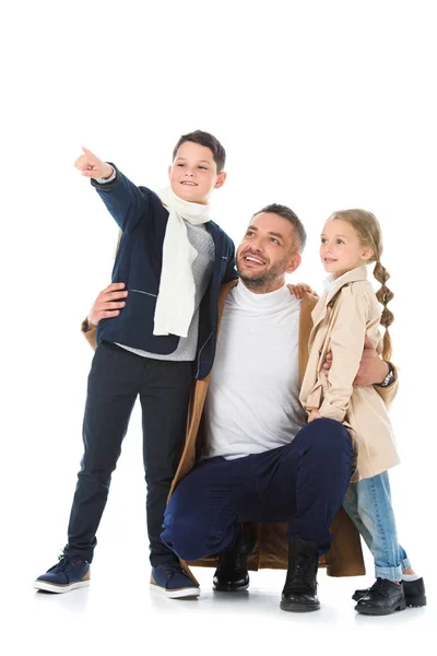 Elegante padre abrazando a los niños en traje de otoño, chico mostrando algo aislado en blanco — Stock Photo