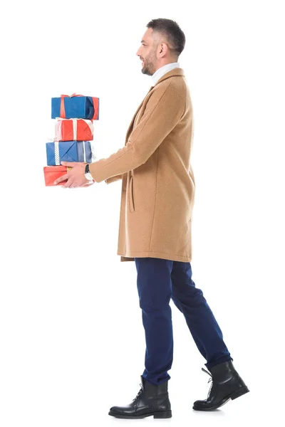 Красивий чоловік у бежевому пальто тримає подарункові коробки, ізольовані на білому — стокове фото