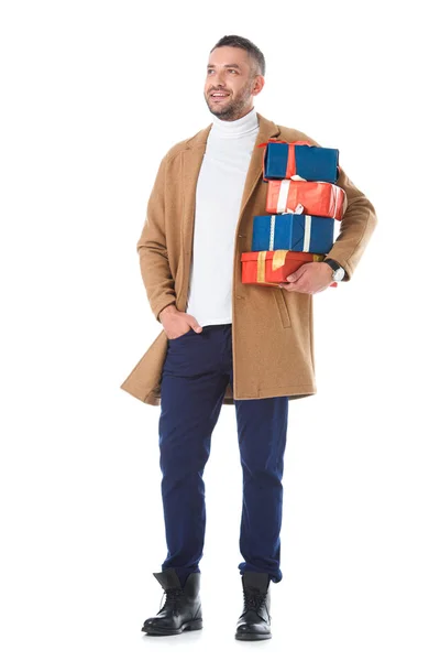 Красивий чоловік в бежевому осінньому пальто тримає подарунки, ізольовані на білому — стокове фото