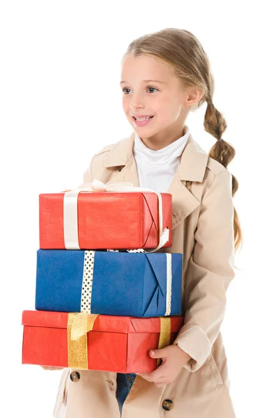 Lächelndes Kind im beigen Mantel mit Geschenken, isoliert auf weiß — Stockfoto