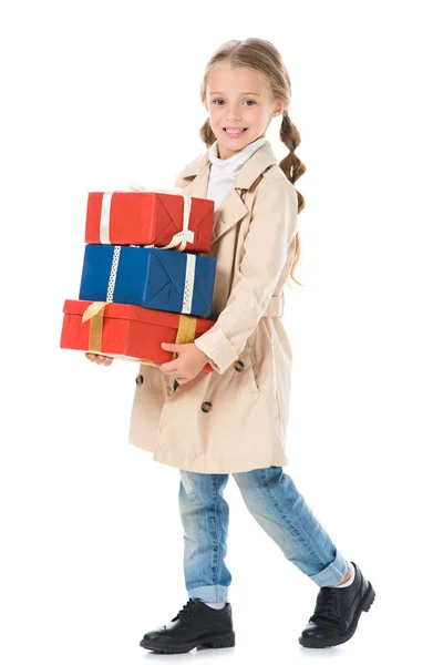 Adorable enfant en manteau d'automne tenant des boîtes-cadeaux, isolé sur blanc — Photo de stock