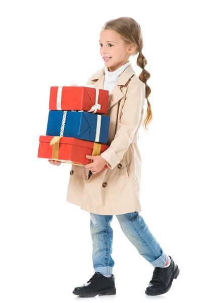 Adorable happy kid in beige coat holding presents, isolated on white — Stock Photo