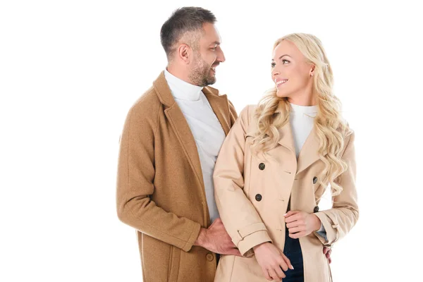 Schöner Ehemann umarmt seine Frau in stilvollem beigen Mantel, isoliert auf weiß — Stockfoto