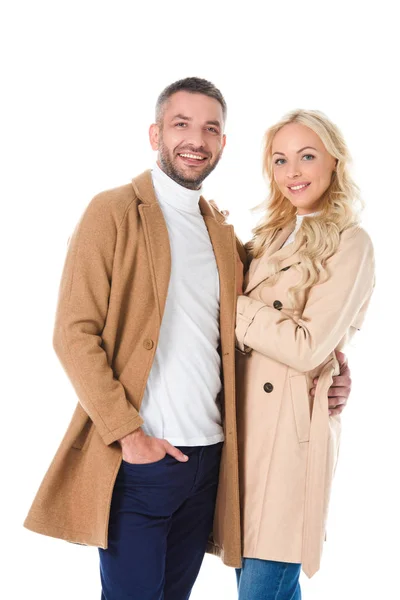 Feliz casal bonito posando em casacos bege, isolado em branco — Fotografia de Stock
