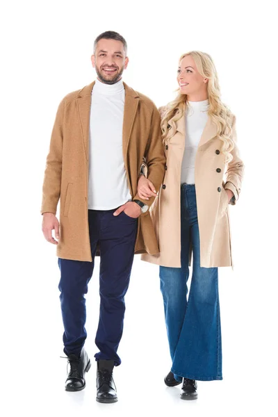Beau couple marchant en manteaux beige, isolé sur blanc — Photo de stock