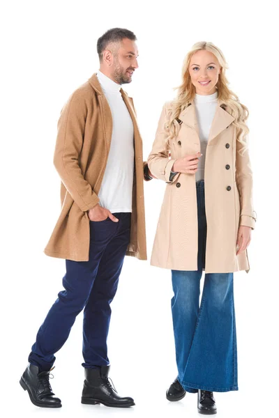 Красива пара позує в бежевих осінніх пальто, ізольована на білому — стокове фото