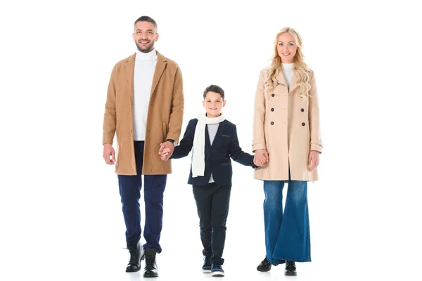 Padres en abrigos beige e hijo tomados de la mano, aislados en blanco - foto de stock