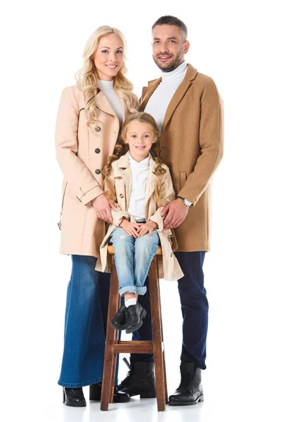 Family with adorable daughter posing in beige autumn coats, isolated on white — Stock Photo