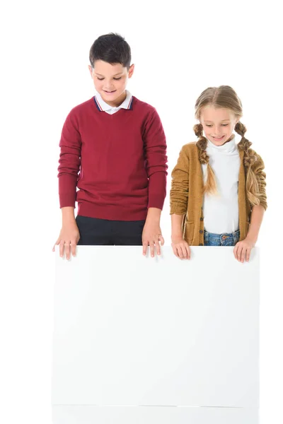 Frère et soeur debout avec planche vide, isolé sur blanc — Photo de stock