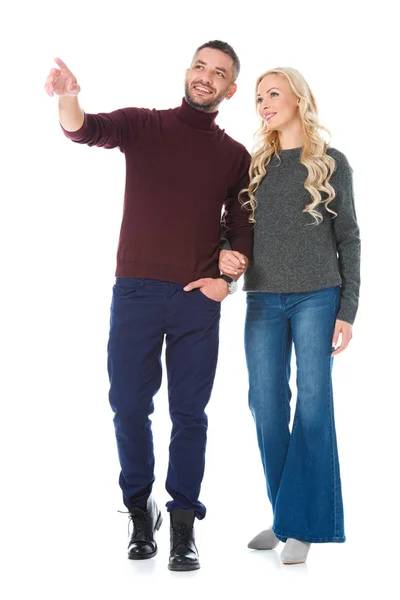 Pareja posando en traje de otoño, hombre mostrando algo aislado en blanco - foto de stock