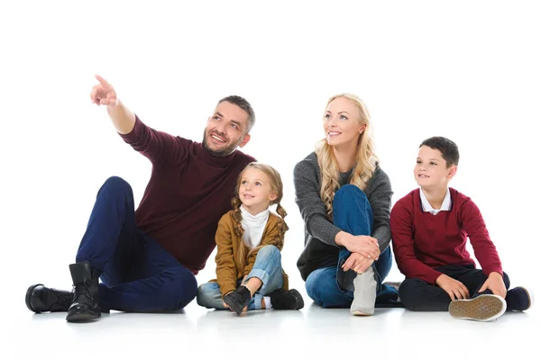 Happy parents sitting together with kids, father showing something isolated on white — Stock Photo