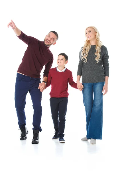 Familia cogida de la mano con el hijo en traje de otoño, hombre apuntando a algo aislado en blanco - foto de stock