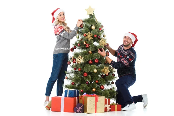 Glückliches Paar schmückt Weihnachtsbaum mit Geschenkschachteln, isoliert auf weiß — Stockfoto