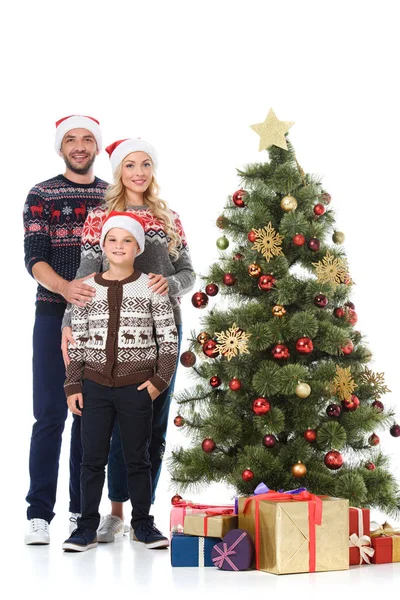 Familia con hijo de pie cerca del árbol de Navidad con regalos, aislado en blanco - foto de stock