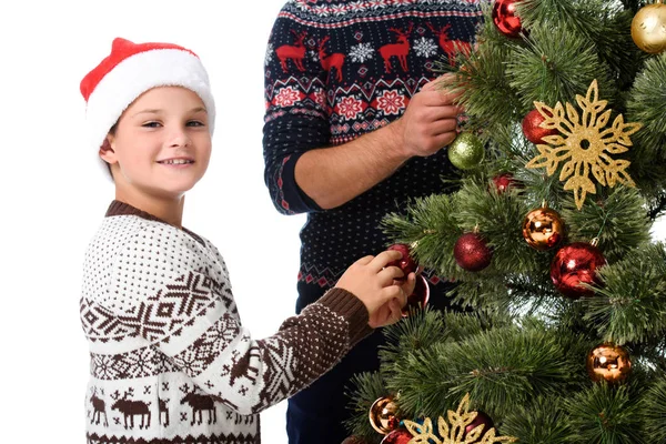 Fils en santa chapeau et père décorer arbre de Noël avec des boules, isolé sur blanc — Photo de stock