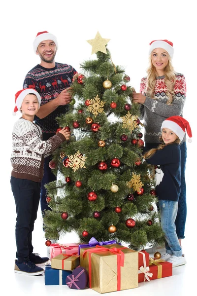 Happy family decorating christmas tree with presents, isolated on white — Stock Photo