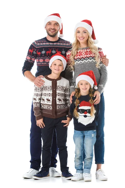 Happy family with kids posing in christmas sweaters and santa hats, isolated on white — Stock Photo