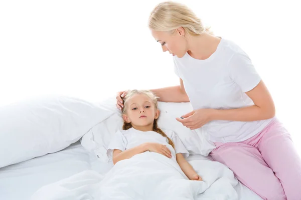 Мати з електронним термометром дивиться на хвору дочку в ліжку, ізольована на білому — стокове фото