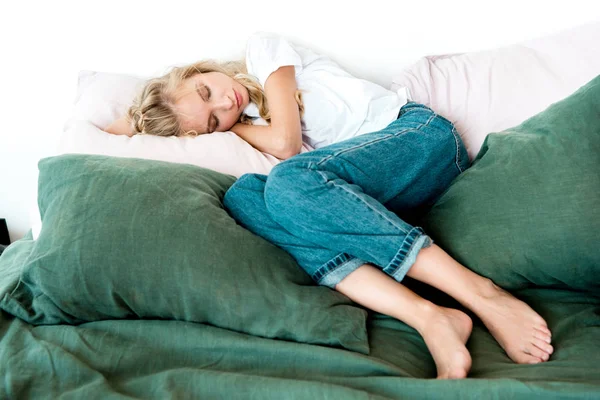 Junge Frau in legerer Kleidung schläft zu Hause auf Kissen auf dem Bett — Stockfoto