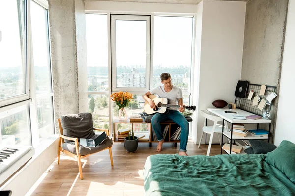 Junger Mann spielt zu Hause Akustikgitarre — Stockfoto