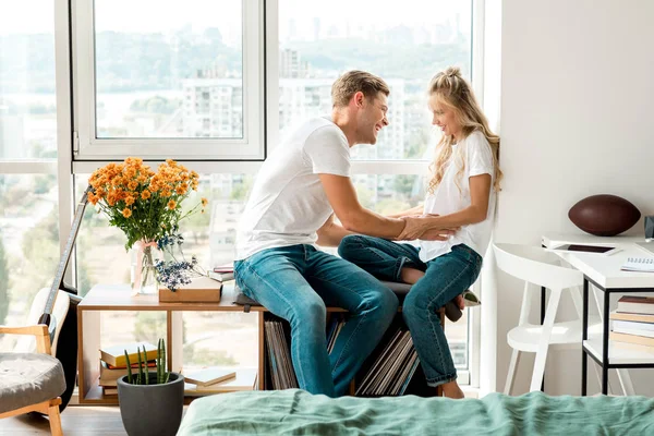 Happy young couple in love sitting at window together at home — Stock Photo
