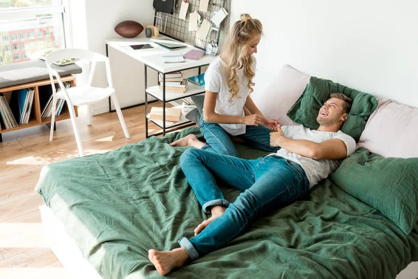 Vue grand angle de jeune couple heureux reposant sur le lit ensemble à la maison — Photo de stock