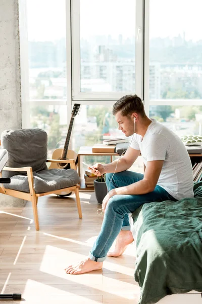 Side view of man in earphones listening music at home — Stock Photo