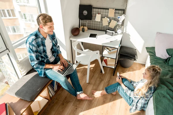 Vista de ángulo alto de pareja con dispositivos digitales en el hogar - foto de stock