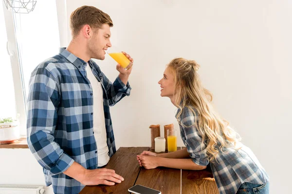 Вид сбоку на молодую пару, завтракающую на кухне дома — стоковое фото