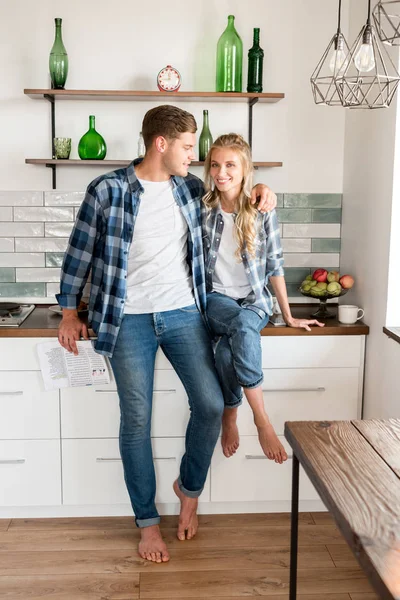 Couple aimant souriant en vêtements décontractés dans la cuisine à la maison — Photo de stock