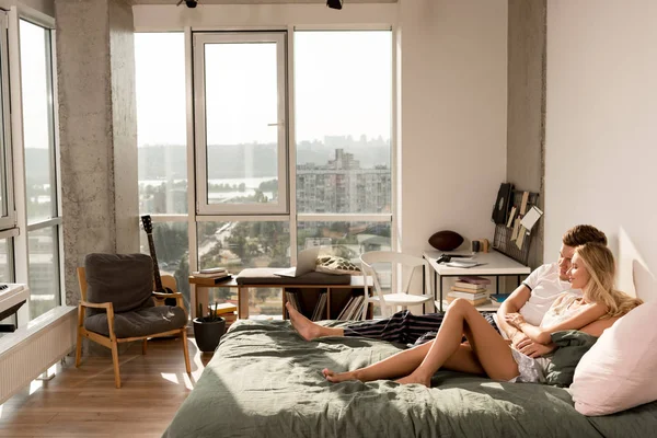 Любящая пара в пижаме, обнимающаяся в постели утром дома — стоковое фото