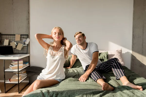 Loving couple in pajamas on bed at home in morning — Stock Photo